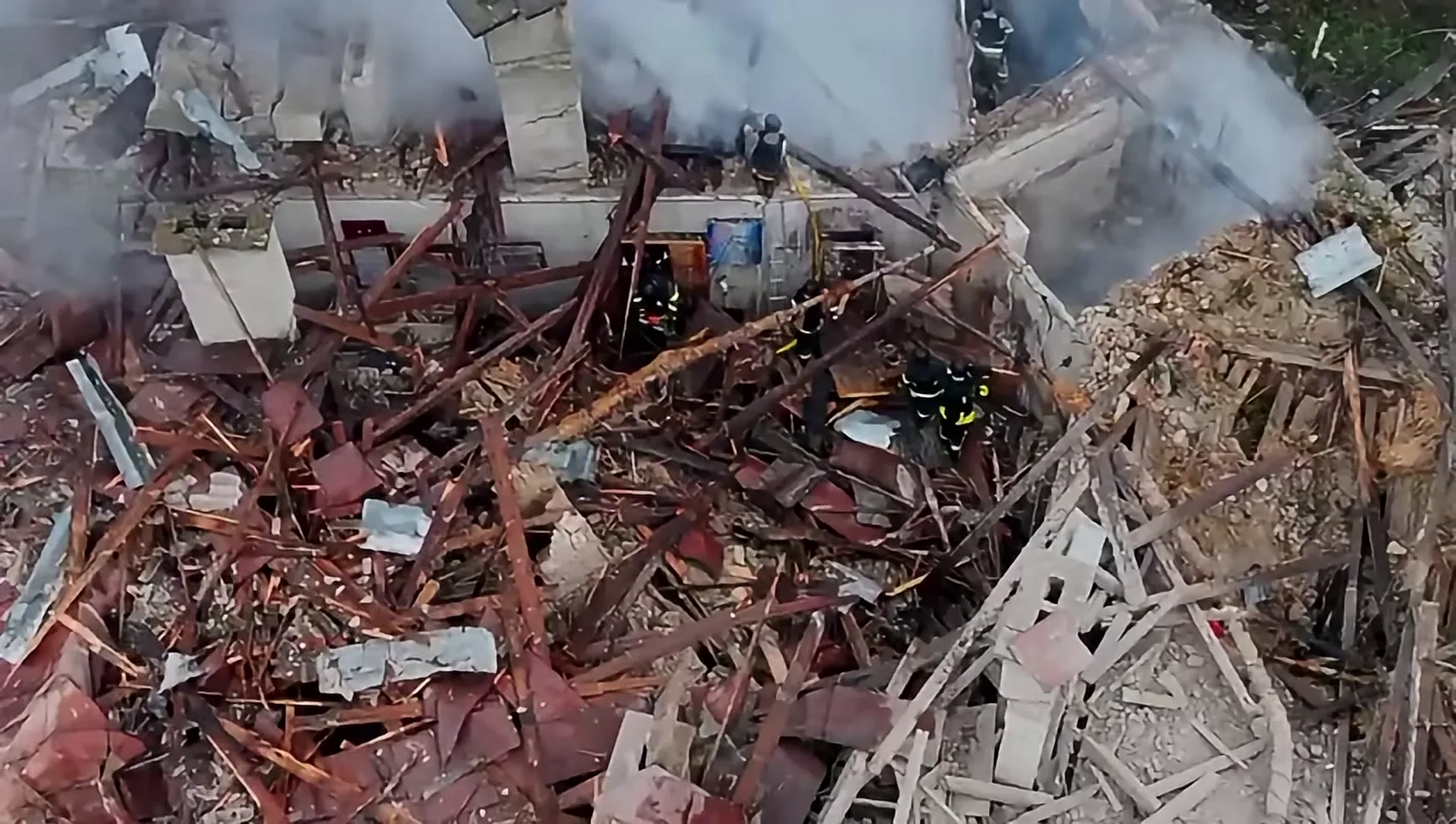 Frame at 18 s: aerial view of the collapsed roof with rescuers.