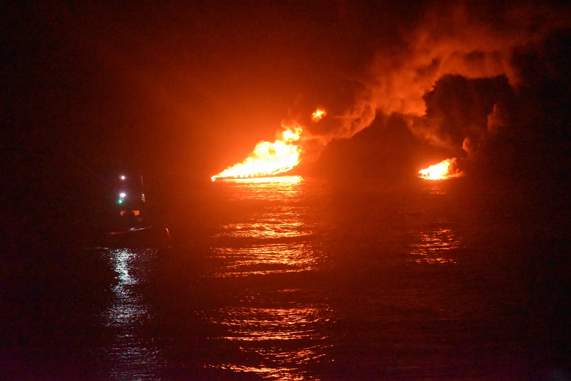 The photo itself (6000x4000 original): a burning vessel at night with a Coast Guard small boat nearby; no people visible.
